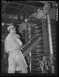 Removing cotton cake from hydraulic presses after oil has been removed. Cotton seed oil mill. McLennan County, Texas by Russell Lee