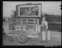 Loading milk cans onto trailer at creamery. San Angelo, Texas by Russell Lee