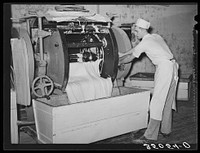 Emptying the dough from mixing machine into the moveable rising vats. Bakery, San Angelo, Texas by Russell Lee