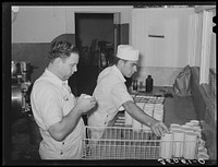 [Untitled image, possibly related to: Scraping surplus ice cream mix from filled cartons with a spatula. Creamery, San Angelo, Texas] by Russell Lee