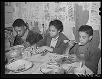Children of Pomp Hall,  tenant farmer, eating their supper. For supper the family had corn bread, peas, gravy, rice, fried bacon and turnips. See general caption number 23. Creek County, Oklahoma by Russell Lee