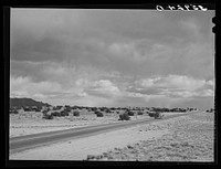 Highway crossing the desert in Sandoval County, New Mexico by Russell Lee