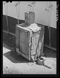 Morman refrigerator used by caretaker at Tonto National Monument. Gila County, Arizona. Water placed in tin container on top drips over the burlap and rapid evaporation in the atmosphere produces the cooling effect by Russell Lee