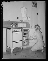 Wife of member of the Arizona part-time farms, Chandler Unit, Maricopa County, Arizona, at her kitchen stove by Russell Lee
