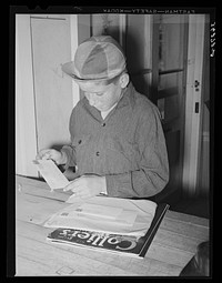 Little boy receiving his family's mail at the post office of the Casa Grande Valley Farms. Pinal County, Arizona by Russell Lee