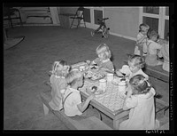Children eating their lunch at the WPA (Work Projects Administration) nursery school at the Casa Grande Valley Farms. Pinal County, Arizona by Russell Lee
