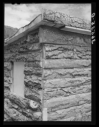 Detail of corner of slab house, Pie Town, New Mexico. Sawmill gives these slabs to farmers who will haul them away; however, they are not in great usage for house construction partly because the farmers have no facilities for hauling and because they do not make as warm and durable houses as the dugout and pine logs by Russell Lee
