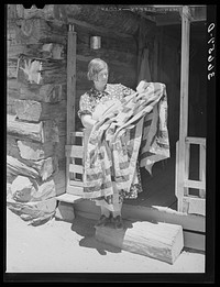 [Untitled photo, possibly related to: Mrs. Bill Stagg exhibiting a quilt made from tobacco sacks which she ripped up, dyed, and pierced. Nothing is wasted on these homesteading farms. Pie Town, New Mexico] by Russell Lee