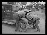 Garage owner and farmer working on a car. Pie Town, New Mexico. The young man who owns the filling station, smith shop, and garage came out from Texas when he could not get work either on the farms or in the farming community towns there by Russell Lee