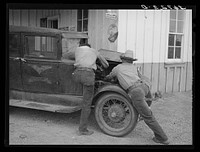 Garage owner and farmer working on a car. Pie Town, New Mexico. The young man who owns the filling station, smith shop, and garage came out from Texas when he could not get work either on the farms or in the farming community towns there by Russell Lee