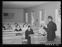 Mr. Whinery, homesteader and licensed preacher, reading the Sunday School lesson in the Farm Bureau building. Pie Town, New Mexico. Mr. Whinery donates his services as a preacher to the church by Russell Lee