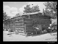 Log house built by a homesteader. This homesteader, who was deeded his farm four years ago, is now sick and lives in town, renting his house and farm to a young couple. Pie Town, New Mexico by Russell Lee