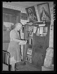 Mrs. George Hutton, homesteader, in front of her bookcase. Pie Town, New Mexico by Russell Lee