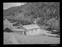 Church surrounded by miners' homes. Mogollon, New Mexico by Russell Lee