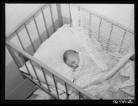 Spanish-American baby in its crib. Chamisal, New Mexico by Russell Lee