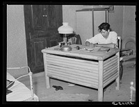 Spanish-American boy working at desk which he made. Notice the similarity in the design of the desk to that of the vigas in the ceiling. Chamisal, New Mexico by Russell Lee