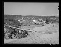 Spanish-American farn near Trampas, New Mexico. Irrigation water crosses ditch in wooden trough by Russell Lee