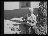 Old Spanish-American farmer with homemade tools. Chamisal, New Mexico by Russell Lee