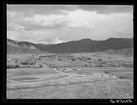 The valley of the Rio Costilla at Amalia, New Mexico. The irrigated farmland is in the center with the grazing land surrounding by Russell Lee