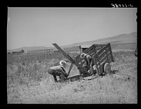 Unloading FSA (Farm Security Administration) cooperative ditcher from trailer. Box Elder County, Utah by Russell Lee
