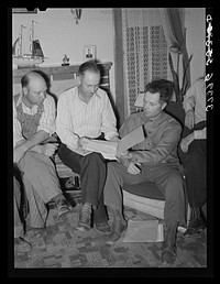 FSA (Farm Security Administration) county supervisor, center, looks over the books of the FSA cooperative stallion organization. Box Elder County, Utah by Russell Lee