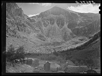 End of mountain valley near Telluride, Colorado, showing road up to mine and Bridal Veil Falls by Russell Lee