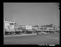 Main street of Brigham, Utah. In the small shopping centers in the Mormon communities the business establishments are likely to be many small ones rather than one large company dominating by Russell Lee