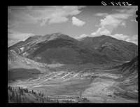 Silverton, Colorado lies in a valley at 9400 feet elevation. This has been a center for mining and milling operations and the tailing-choked Animas River can be seen at left by Russell Lee
