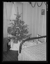 Baby and Christmas tree in corner of living room in home of construction workman. This family came to Corpus Christi from northwest Texas eight months ago by Russell Lee