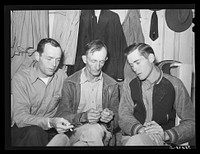 Three men workers at naval air base from Louisiana. These men are living in a tourist court and had to leave their families in Louisiana because they could not find suitable housing facilities. Corpus Christi, Texas by Russell Lee