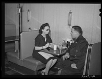 Policeman talking to employee of Ten-cent store whose trade is predominantly . Chicago, Illinois by Russell Lee