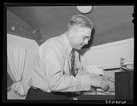 Clerk at the FSA (Farm Security Administration) migratory labor camp mobile unit. Wilder, Idaho by Russell Lee