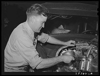 Consolidated Aircrafts workman working on his self-assembled automobile. This is a diesel motor in this car. San Diego, California by Russell Lee