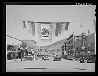 Main street of Vale, Oregon, on the Fourth of July. Vale is one of the shopping centers for the farmers who live and work on the Vale-Owyhee irrigation project by Russell Lee