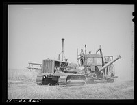 Caterpillar tractor and combine in wheat field on Eureka Flats. Walla Walla County, Washington by Russell Lee