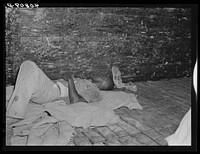 Migratory agricultural worker asleep in boxcar. Camden, North Carolina. Sourced from the Library of Congress.