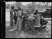 Migrants repairing motor before leaving Old Trap, North Carolina, for New Jersey. Sourced from the Library of Congress.