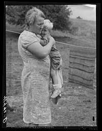 Farm woman holding one of her children in submarginal farm area of Rumsey Hill, near Erin, New York. Sourced from the Library of Congress.