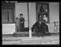 On the porch of Mr. Shoemaker's house. Blind old man and Mr. Shoemaker's children. They are farmers in the submarginal farm area of Rumsey Hill, near Erin, New York. Sourced from the Library of Congress.