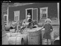 [Untitled photo, possibly related to: Children of Baptiste Deprui, French-Canadian potato farmer. He runs a small seed foundation unit and also raises some certified seed oats. The barrels in front of the house were left there after he had stored all the potatoes in the cellar of the house. The potatoes completely filled the cellar as high as the floor boards. Soldier Pond, Maine]. Sourced from the Library of Congress.