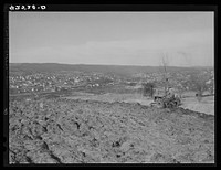Farmer ploughing his field on a hillside opposite the industrial valley including the towns of Darby, Shelton, and Ansonia, Connecticut. Sourced from the Library of Congress.