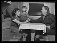 Mr. and Mrs. Clyde Burton and child. Mr. Burton came from Moose Head Lake region, Maine, where he used to run a sportsman's camp. Have been traveling around in a trailer for three years. Had a few weeks work at one of the branches of the iron works a number of months ago, has been unemployed since. Has been trying to get work at the Bath Iron Works but so far has been unsuccessful. Was planning to move to Bath with their trailer the next day. Trailer was about five miles out from center of Bath. Had no electricity and used the sanitary facilities of a house nearby.. Sourced from the Library of Congress.