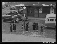 [Untitled photo, possibly related to: Commuters who have just gotten off the train waiting for the bus to go home. Lowell, Massachusetts]. Sourced from the Library of Congress.