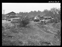 [Untitled photo, possibly related to: Part of a trailer camp for migratory workers, employed at Fort Bragg, North Carolina. Trailer space is one dollar a week, and small bunk houses five dollars a week. One water spigot near the general store serves the whole camp until 6 p.m. On the left is an old trolley car used as living quarters by a small family who came one hundred miles to work at the Fort. Some of the families here came from Texas, Idaho, Georgia, South Carolina and other parts of North Carolina twelve miles from Fayetteville, North Carolina (Manchester)]. Sourced from the Library of Congress.