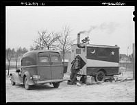This trailer was occupied by two men working at Fort Bragg, North Carolina, who had come from West Virginia. They bought the trailer from a fortune teller at a circus. At a camp near Fayetteville, North Carolina. Sourced from the Library of Congress.