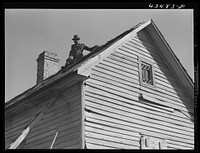 [Untitled photo, possibly related to: Repairing the roof of an old tenant house to be occupied by a  family from the Spartanburg Army camp area. Near Whitestone, South Carolina]. Sourced from the Library of Congress.