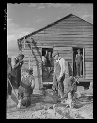 Installing a pump at a house rebuilt for a family who had moved out of the Santee-Cooper basin. Near Bonneau, South Carolina. Sourced from the Library of Congress.