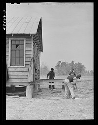 Building a porch for a house that had been carried out of the Santee-Cooper basin by a  family. Near Bonneau, South Carolina region. Sourced from the Library of Congress.