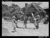 Colie Smith gets a ride on one of two horses owned by the Smith family. Carroll County, Georgia. Sourced from the Library of Congress.