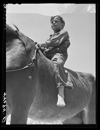 [Untitled photo, possibly related to: Colie Smith gets a ride on one of two horses owned by the Smith family. Carroll County, Georgia]. Sourced from the Library of Congress.